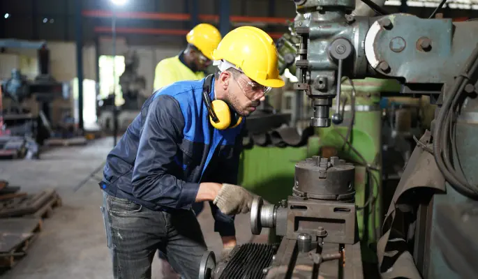 Maintenance engineer monitoring equipment and reliability indicators in a control environment